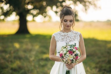 Güzel gelin buketi konumu alan büyük ağaç arka planda ortasında olan