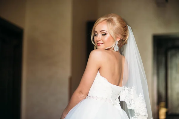 Retrato de una novia en un vestido de novia. La novia se viste en el hotel — Foto de Stock