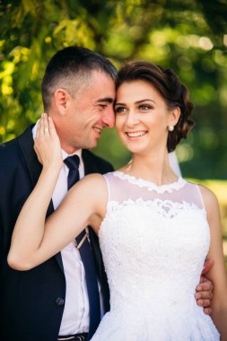 Genç çift, gelin ve damat yürüyüş ve onların düğün günü zevk. Güneş ışığı. Yaz