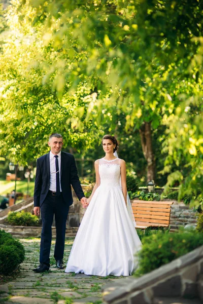 Casal jovem, noiva e noivo andando e desfrutando de seu dia de casamento. Luz do sol. Verão — Fotografia de Stock