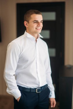 Damat takım elbiseli evde giyindi. Şirin damat bir fotoğrafçısına poz