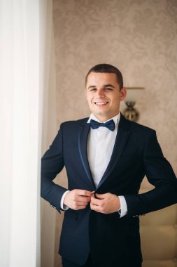 Bir düğün günü stand pencerenin yakınındaki yakışıklı damat