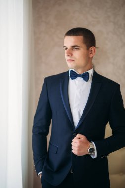 Bir düğün günü stand pencerenin yakınındaki yakışıklı damat