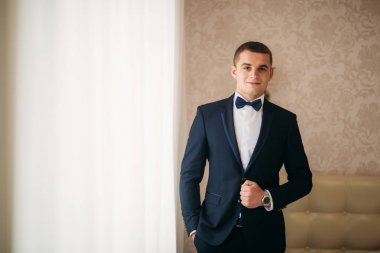 Bir düğün günü stand pencerenin yakınındaki yakışıklı damat