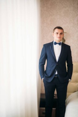 Bir düğün günü stand pencerenin yakınındaki yakışıklı damat
