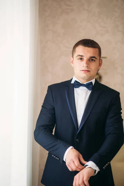 Schöner Bräutigam am Hochzeitstag am Fenster — Stockfoto