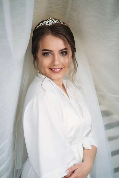 Portrait of the bride in a negligee under the white curtain — Stok Foto