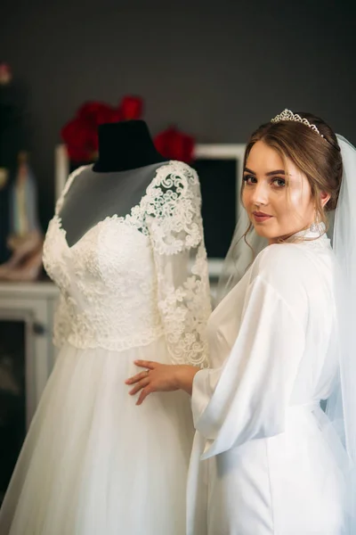 Linda novia vestida en casa en un vestido de novia — Foto de Stock
