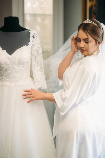 Pengantin yang lucu berpakaian di rumah dengan gaun pengantin — Stok Foto