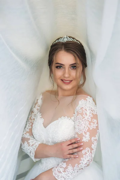 흰색 커튼 아래 웨딩 드레스에서 신부 초상화 — 스톡 사진