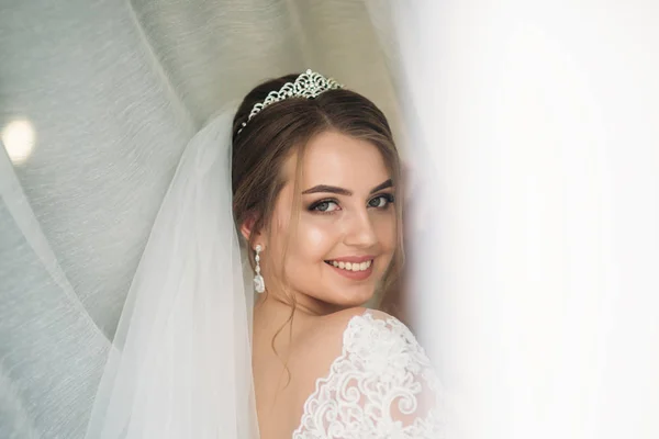 흰색 커튼 아래 웨딩 드레스에서 신부 초상화 — 스톡 사진