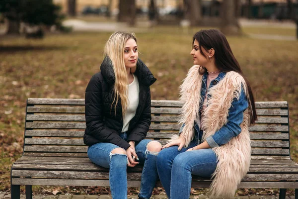 Duas meninas sentadas no banco ao ar livre — Fotografia de Stock