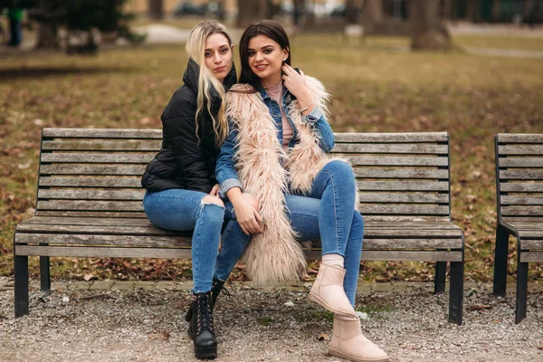 Zwei Mädchen sitzen auf der Bank im Freien — Stockfoto