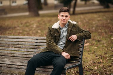 İyi adam bulutlu havalarda açık havada bankta oturmuş