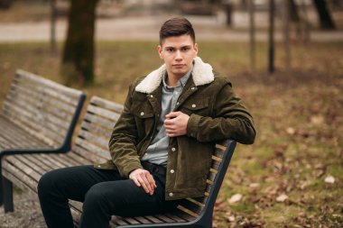 İyi adam bulutlu havalarda açık havada bankta oturmuş