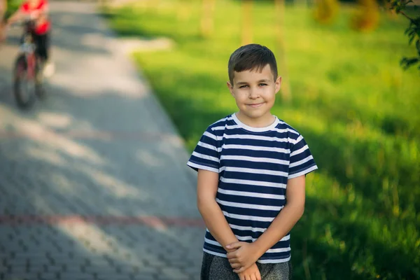 Jongetje in een gestreepte t-shirt kijkt door een verrekijker. Lente, zonnig weer — Stockfoto