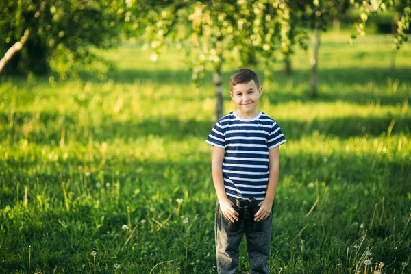 Ragazzino in t-shirt a righe guarda attraverso binocoli. Primavera, tempo soleggiato — Foto Stock