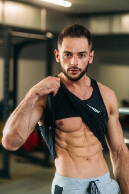 Genç bir atlet spor salonunda eğitiyor. Adbominal kasları gösterir