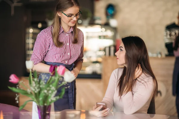 Kellnerin nimmt Bestellung von ihrem Kunden in einem Café entgegen — Stockfoto