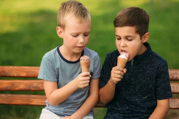 Két gy ül a padon, és eszik fagylaltot — Stock Fotó