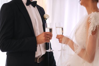Yeni evlilerin ortanca seçimi bir kadeh şampanya tutuyor.