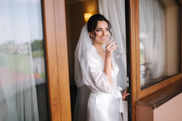 Retrato de la novia hermosa en el hotel por la mañana. Encantadora mujer con gran peinado y maquillaje —  Fotos de Stock