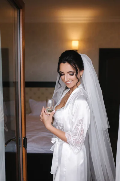 Retrato de la novia hermosa en el hotel por la mañana. Encantadora mujer con gran peinado y maquillaje —  Fotos de Stock