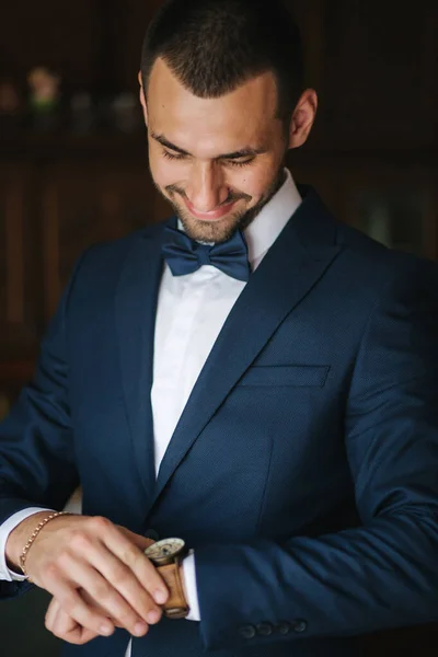 Şık, koyu mavi takım elbiseli, papyonlu yakışıklı damat. — Stok fotoğraf