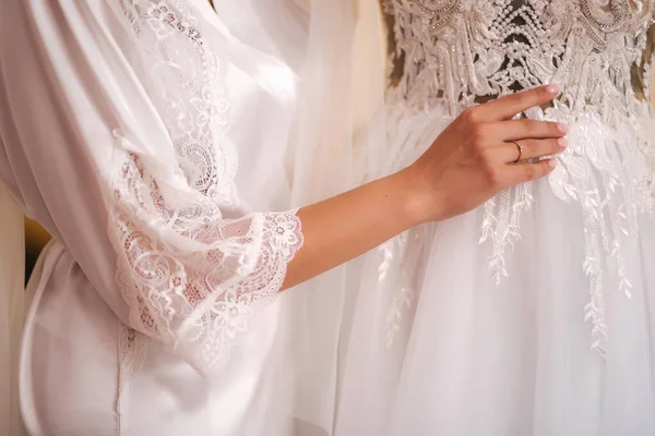 Красивая невеста стоять у свадебного платья утром — стоковое фото