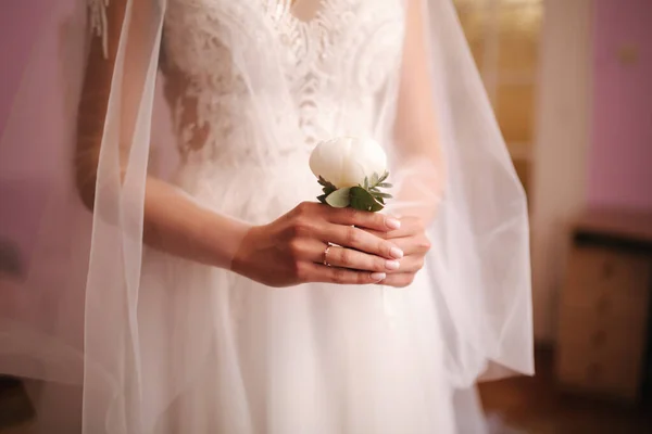 Закрытие невесты, держащей в руках бутоньерку для жениха — стоковое фото