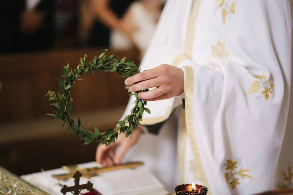 A pap közeli kezei a templomban az esküvőn — Stock Fotó