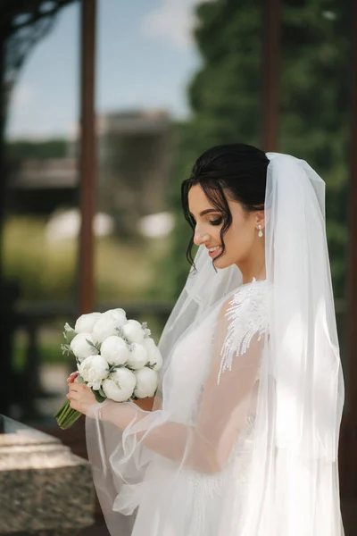 Linda noiva em vestido de noiva elegante com buquê de flores brancas em seu dia do casamento — Fotografia de Stock