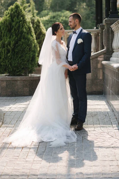 Gyönyörű menyasszony a jóképű vőlegényével, aki odakint sétál Theri esküvőjén. Boldog friss házasokat. — Stock Fotó