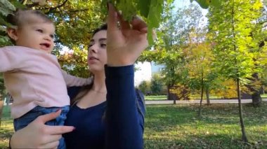 Anne ve kızı sonbaharda bir araya gelirler. Güzel on aylık bebek annesinin ellerinde.