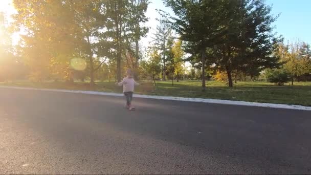 Adorable niña pequeña caminar en el parque en octubre. Lindo paseo de diez meses. Hermosa chica feliz. Humor de otoño — Vídeos de Stock