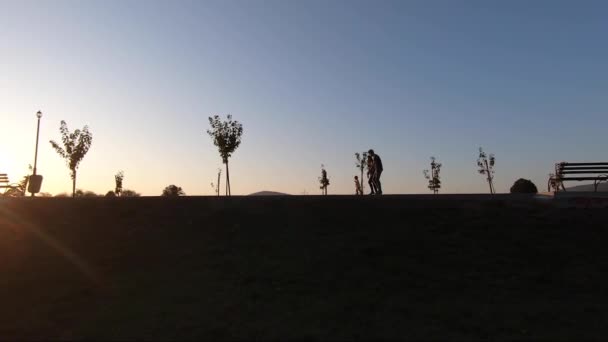 Silhouette di mamma papà e figlia che camminano nel parco anche se l'embakment. Famiglia felice trascorrere del tempo insieme — Video Stock