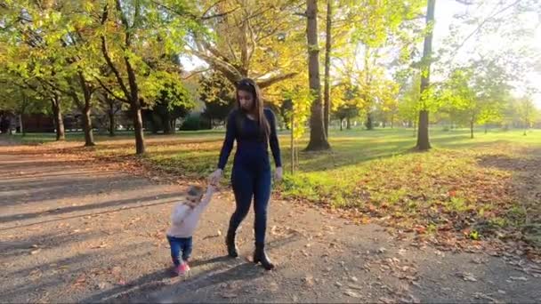 Adorable little girl walking in the park with mom in october. Cute ten month baby walk. Beautiful happy girl. Autumn mood — Stock Video
