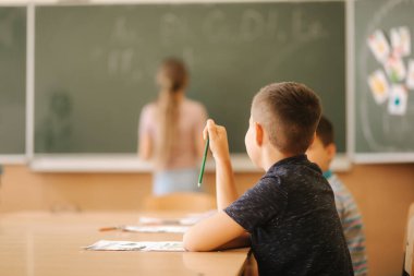 Sınıfta kalem ve defter yazan bir grup okul çocuğu. eğitim, ilkokul, öğrenme ve insan kavramı