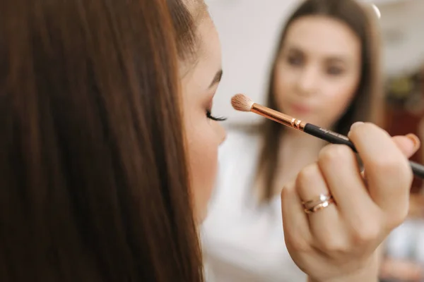 Makeup artist applies eye shadow, perfect evening makeup. Beauty redhead girl with perfect skin and freckles — Stock Photo, Image