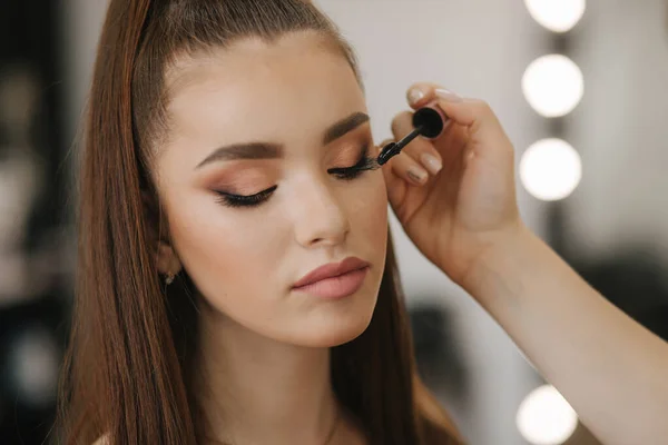 La modella ha un trucco da truccatore nel salone di bellezza. Vista in prima persona. Modello rossa con lentiggini. Primo piano di modelli viso con make up — Foto Stock