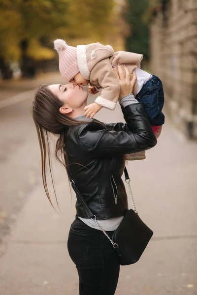 O fetiță adorabilă pe mâna mamelor în parc. Mama cu fiica merge afară. O familie fericită în toamna de aur — Fotografie, imagine de stoc