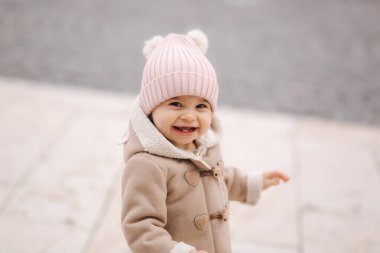 Ceketli ve şapkalı bir kızın portresi. Dışarıda sevimli bir bebek var.