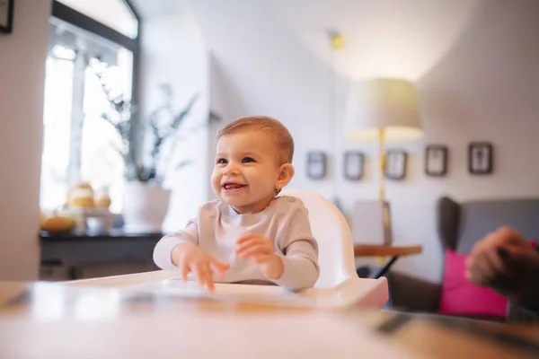 Retrato de una adorable niña en la trona. Bebé riendo y jugando. Chica feliz sonrisa — Foto de Stock