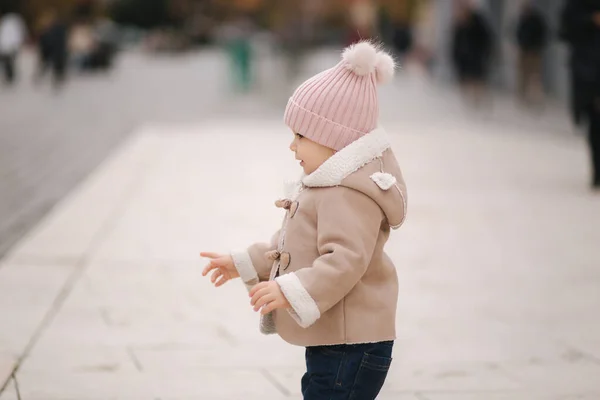 Linda niña de once meses baila en el centro de la ciudad. Niña feliz afuera en otoño — Foto de Stock
