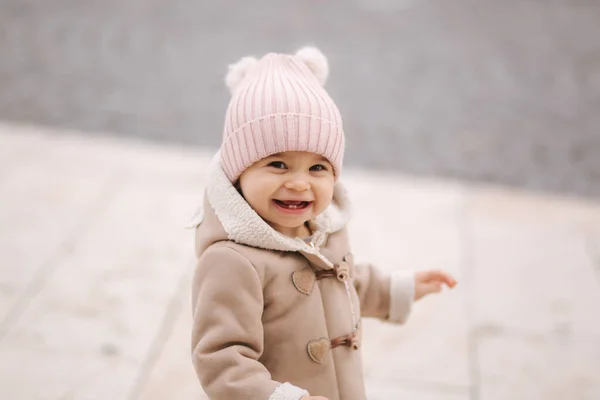 Portrait of baby girl in coat and hat laughing. Cute baby outside — Stock Photo, Image