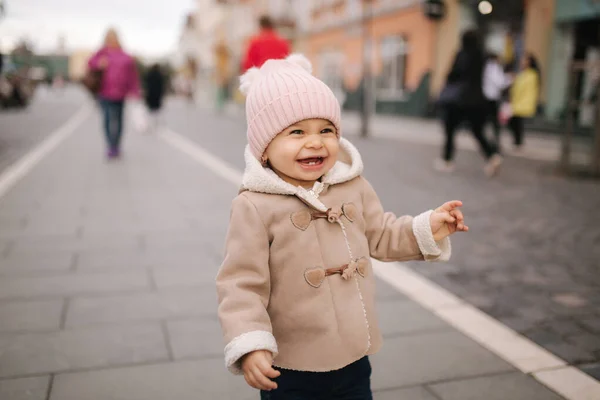 Portret van een klein meisje met een lachende jas en hoed. Schattige baby buiten — Stockfoto