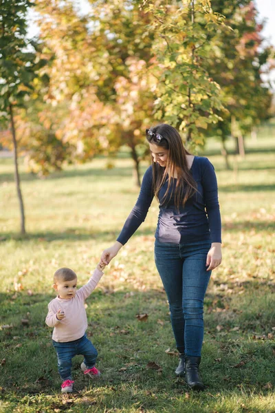 Felice passeggiata bambina con la mamma in autunno nel parco — Foto Stock