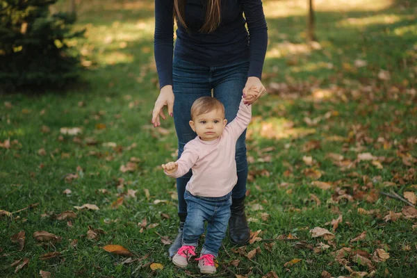 Lycklig liten flicka gå med mamma på hösten i parken — Stockfoto