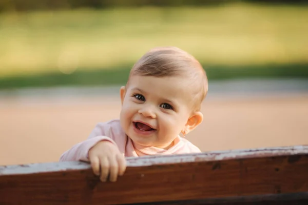 Primer plano de la hermosa niña sonriente. Niña feliz en el parque de otoño. Sonrisa de bebé de diez meses — Foto de Stock