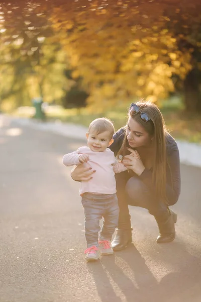 Menina feliz caminhar com a mãe no outono no parque — Fotografia de Stock